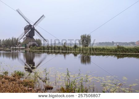 On The Water There Are Several Windmills In Kinderdijk In Holland