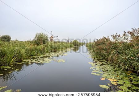 On The Water There Are Several Windmills In Kinderdijk In Holland