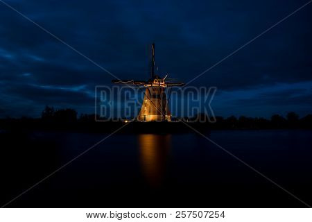 These Beautiful Windmills In Kinderdijk Are Illuminated With White Light At The Blue Hour