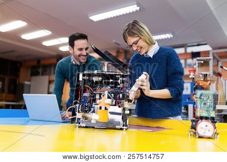 Young Attractive Students Of Mechatronics Working On Project