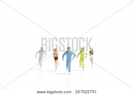 Miniature People Running On White Background , Healthy Lifestyle And Sport Concepts.