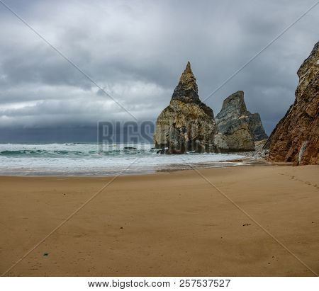 Praia Da Ursa Beach With Sand And Stormy Clouds