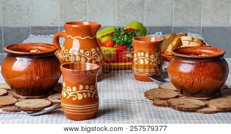 Traditional Rustic Home  Gulyas, With Raw Vegetables And Spices In Clay Pots On  Old Vintage Wooden 