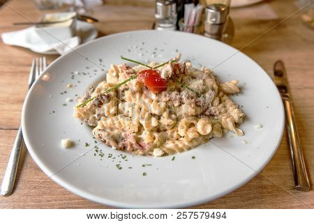 Colorful Plate With Penne Pasta With Prosciutto And Spinach On A Table