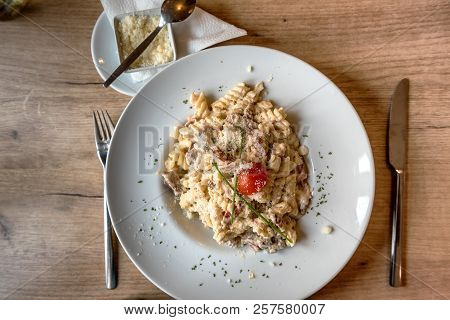 Colorful Plate With Penne Pasta With Prosciutto And Spinach On A Table