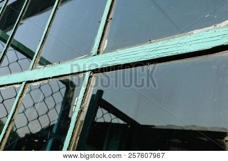 Old Window With Unwashed Windowpane And Chapped Window Frame Painted Green And Rusty Nails Close Vie