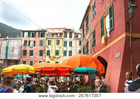 Monterosso Italy - April 24 2011;  Crowd Of Tourists Under Bright Umbrellas In Town Square Piazza G 