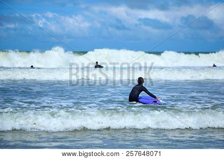 Little Boy Going To The Sea Waves With A Surfboard In His Hands. Surfer School. Kids Outdoor Water S