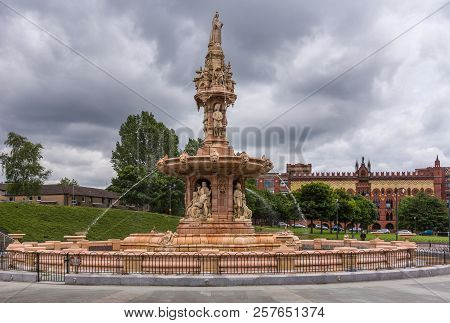 Glasgow, Scotland, Uk - June 17, 2012: Doulton Fountain On Glasgow Green Under Heavy Cloudscape. Gre