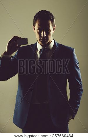 Man, Businessman Or Manager Holding Bank Or Business Card In Stylish Blue Formal Suit And Tie On Gre