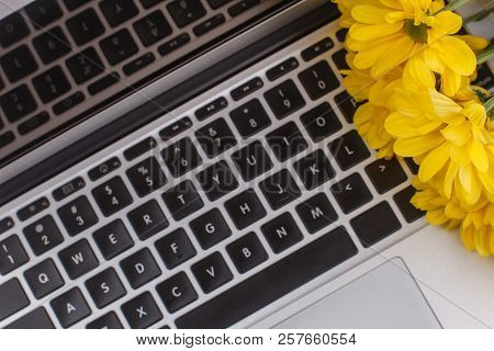 Laptop Keyboard And Yellow Flowers Close Up. Bouquet Of Sunchoke Flowers.