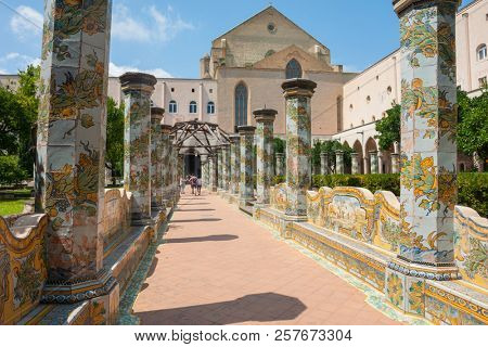NAPLES, ITALY - AUGUST 1, 2018: Sunny cloister of the Clarisses decorated with majolica tiles from Santa Chiara Monastery in Naples, Italy. 
