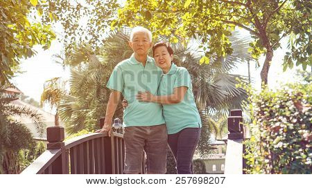 Happy Asian Elderly Couple Laugh Together In Green Natural Park Background