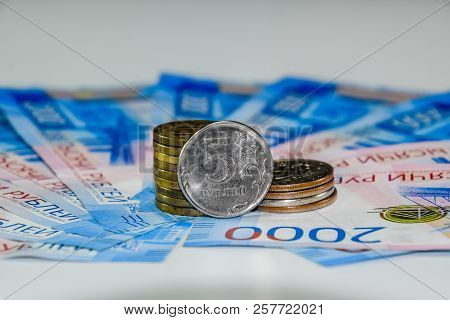 Russian Banknotes And Coins. A Handful Of Coins On New Russian Banknotes In Denominations Of 2000 An