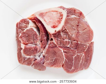 Top View Of Slice Of Raw Veal Meat With Marrowbone For Italian Dish Ossobuco On White Plate