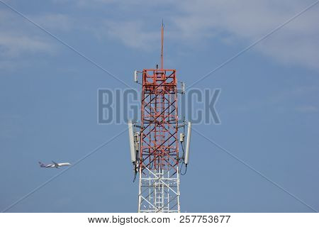 Mobile Phone Tower With Blue Sky And Airplane Background