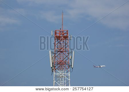 Mobile Phone Tower With Blue Sky And Airplane Background