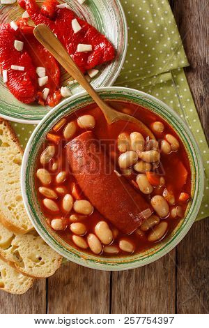 Pasulj (grah) Bean Soup With Sausage Is Served With Bread And Bell Pepper Close-up On A Plate. Verti