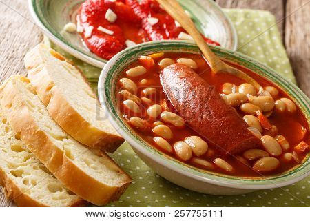 Home-made Bean Soup With Sausage Is Served With Bread And Bell Pepper Close-up. Horizontal