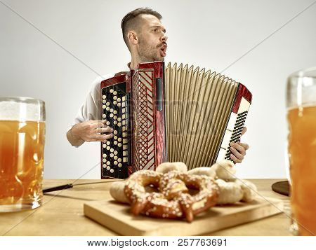 Man In Traditional Bavarian Clothes Playing Accordion. Germany, Bavaria, Upper Bavaria. The Young Ha