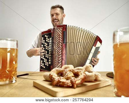 Man In Traditional Bavarian Clothes Playing Accordion. Germany, Bavaria, Upper Bavaria. The Young Ha