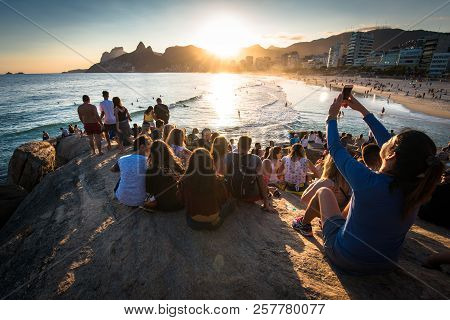Rio De Janeiro, Brazil - August 18, 2018: People Sitting All Around On Arpoador Rock And Enjoying Be