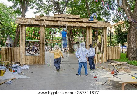Phnom Penh, Cambodia - April 8, 2018: Workers  Making A Temporary Gate Out Of Bamboo Stems  In A Gar