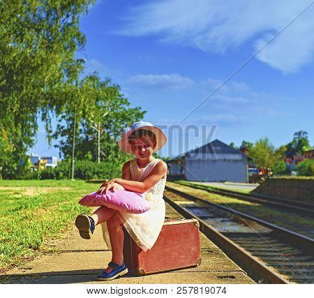Adorable Little Girl On A Railway Station, Waiting For The Train With Vintage Suitcase. Traveling, H