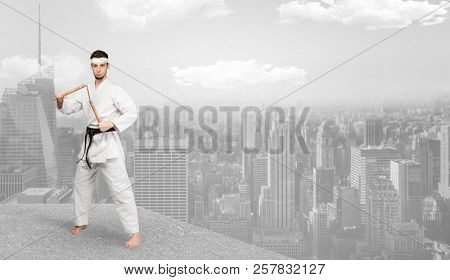 Young karate trainer doing karate tricks on the top of a metropolitan city