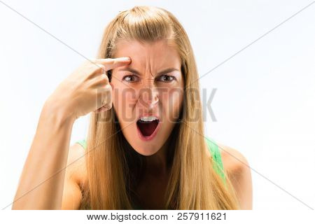 Portrait of an angry young woman shouting against white background