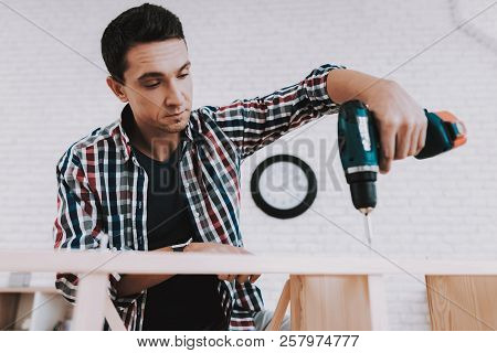 Young Man Assembling Wooden Bookshelf At Home. Wooden Bookcase. Selfmade Furniture. Man And Hobby. W