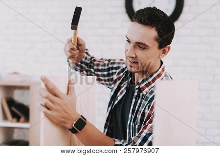 Young Man Assembling Wooden Bookshelf At Home. Wooden Bookcase. Selfmade Furniture. Man And Hobby. W