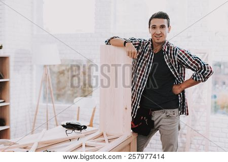 Young Man Assembling Wooden Bookshelf At Home. Wooden Bookcase. Selfmade Furniture. Man And Hobby. W