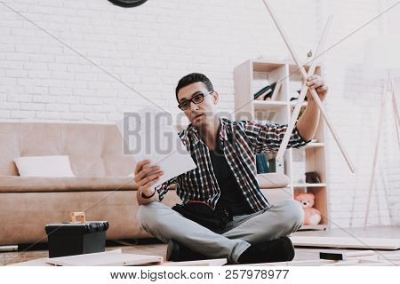 Young Man Assembling Wooden Bookshelf At Home. Wooden Bookcase. Selfmade Furniture. Man And Hobby. W