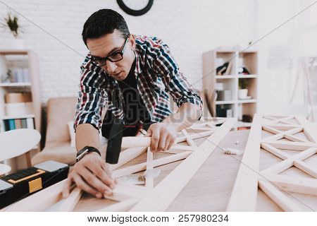 Young Man Assembling Wooden Bookshelf At Home. Wooden Bookcase. Selfmade Furniture. Man And Hobby. W