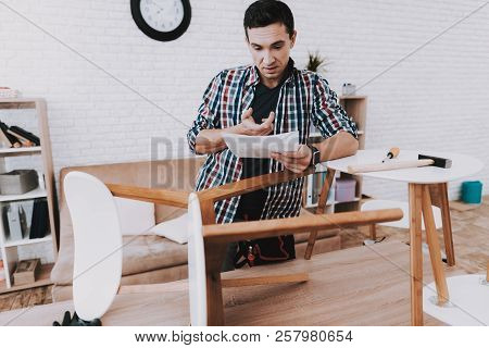 Young Man Assembling Coffee Table And Stools. Furniture Fittings. Engineer With Tool. Young Man At H