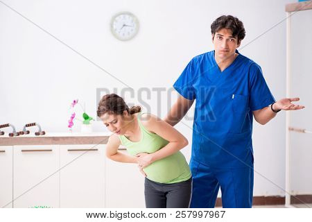 Pregnant woman doing physical exercies with instructor