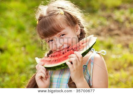 Funny, Dark-haired Girl With Pigtails Eating A Watermelon