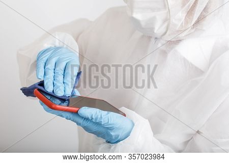 Hands In Protective Gloves And Siut Cleaning Phone From Dust And Infection On White Background