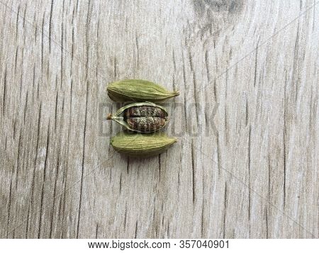 Top View Of Dried Green Cardamom Pod And Seeds Isolated On Wooden Background. Close Up.