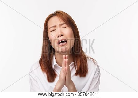Close-up Portrait Of Hopeless And Desperate Asian Woman Whining, Pleading With Hands In Pray, Clench