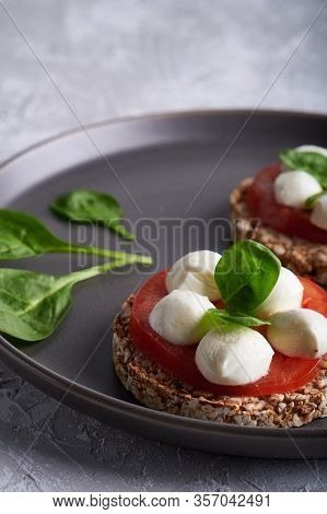 Toasts With Mozzarella, Tomatoes And Spinach In A Gray Plate