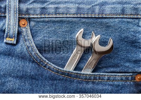 Blue Jeans Front Pocket With Chrome Lug Wrench. Close Up View. Libor Day Concept