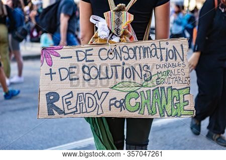 French Placard Which Translates As Less Consumerism And More Solutions, Is Seen Close Up During A Cl