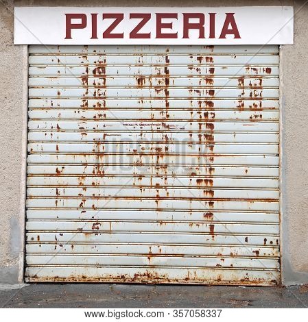 Closed Portcullis Of The Pizzeria Due To The World Economic Crisis And The Big Text