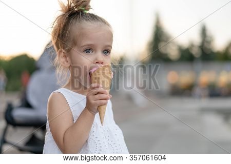 Little Caucasian Girl 3 Years Old Eats Ice Cream Closeup Portrait. Summertime. Childhood Child With 