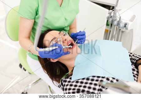 Young Beautiful Woman Treats Teeth At The Dentist Cabinet. Dental Treatment Process