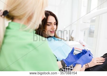Dentist Doctor Shows The Patient A Jaw Model And Talks About The Upcoming Treatment.