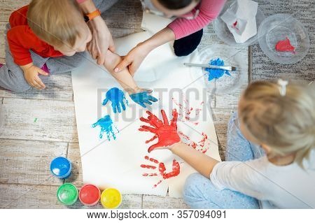 Adorable Cute Caucasian Little Blond Siblings Children Enjoy Having Fun Together With Mother Paintin