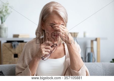 Tired Older Lady Suffering From Dry Eyes Syndrome.